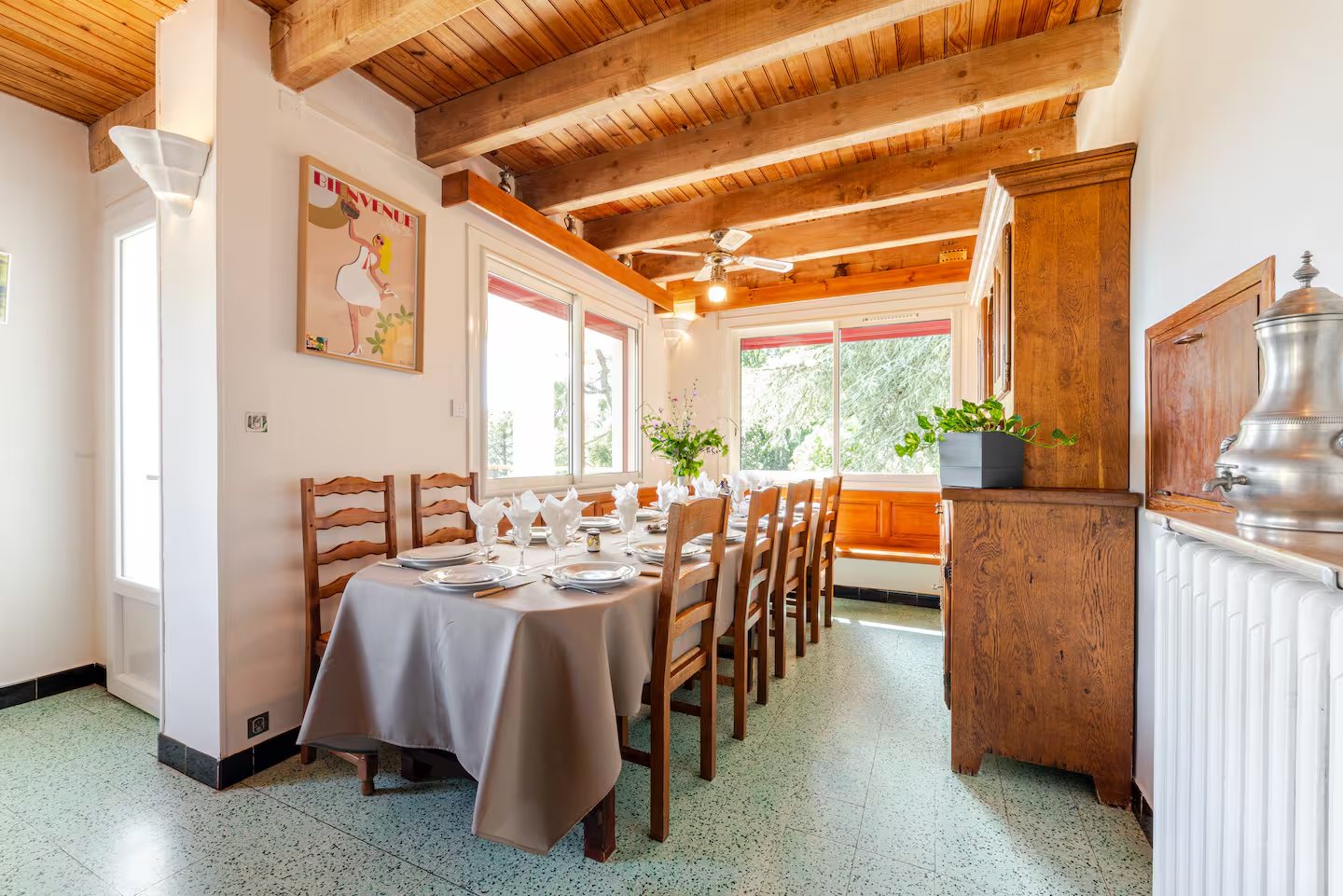 Salle à manger lumineuse avec poutres apparentes à la Villa Les Cèdres
