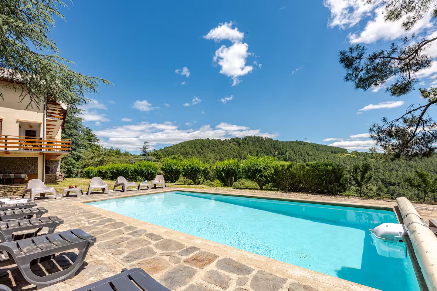 Piscine chauffée de la Villa Les Cèdres avec transats et vue sur les Cévennes